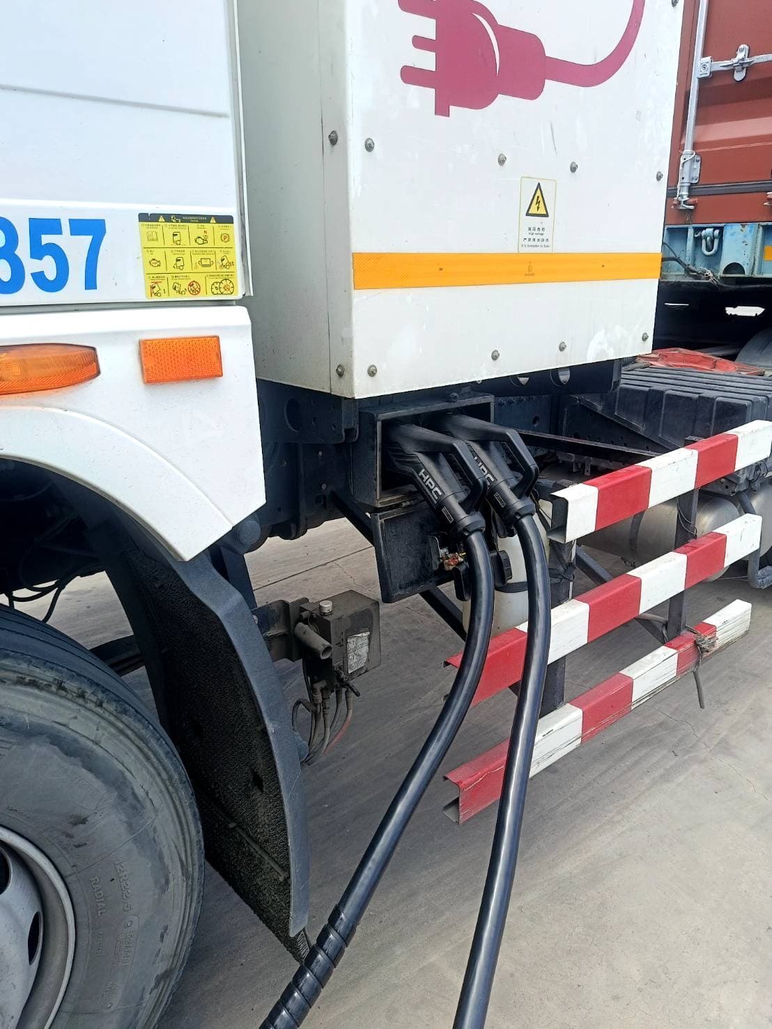 A high-power charging connector plugged into an electric truck's charging port