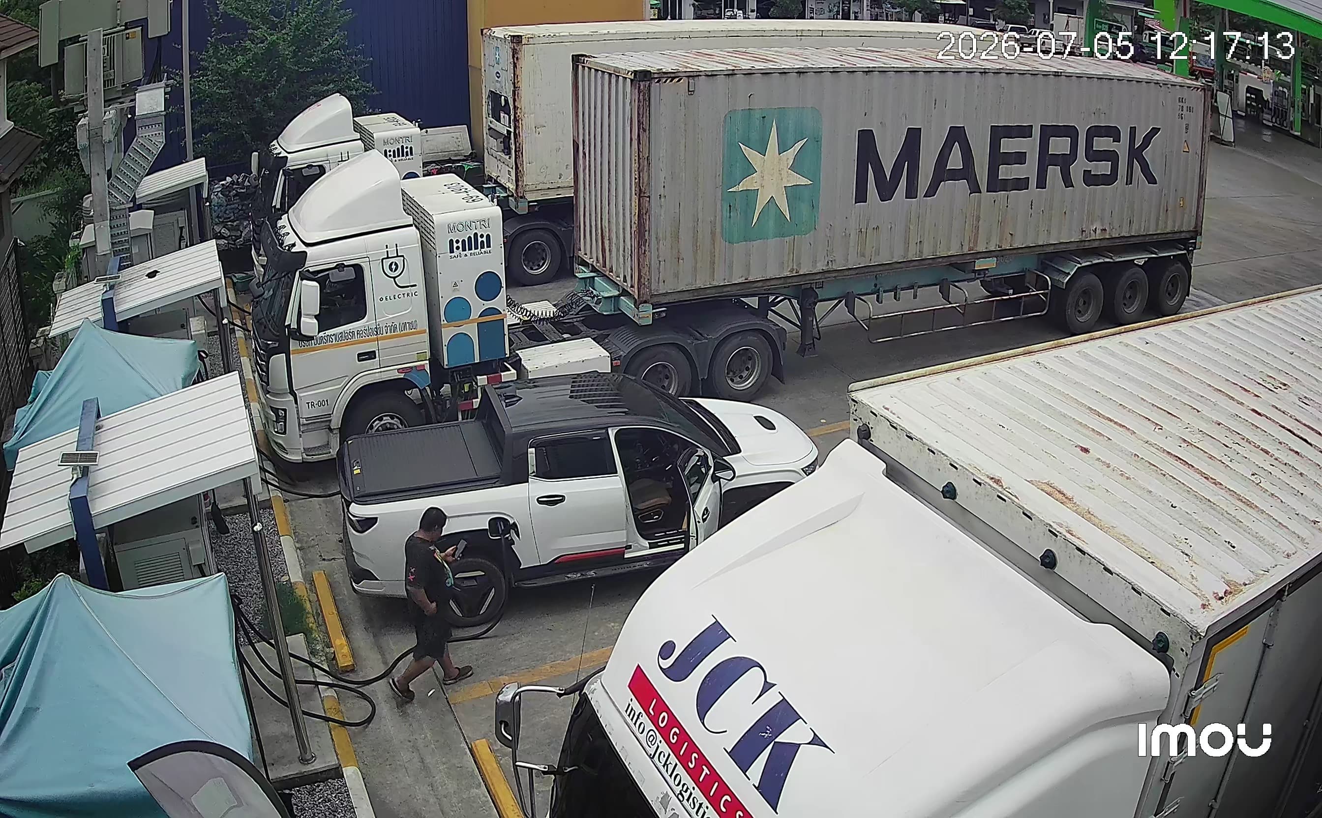 A MONTRI-converted electric truck charging on the ProCharge network, beside a Maersk shipping container